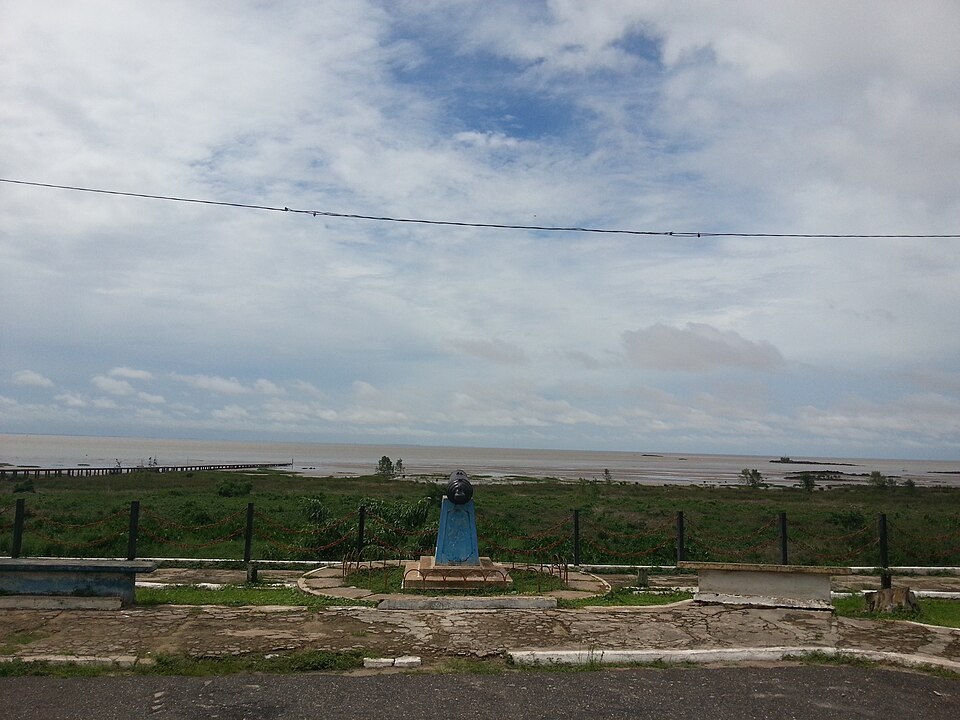 Vista diurna da Baía do Marajó a partir da orla de Colares, com céu, água e calçadão